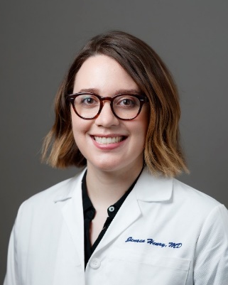 A person wearing glasses and a white coatDescription automatically generated